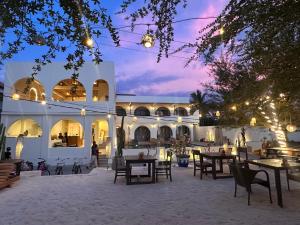a courtyard of a building with tables and chairs at Segreto Boutique Resort in Gili Trawangan