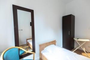 a bedroom with a bed and a mirror and a chair at Hôtel Le Paris Brest in Lens