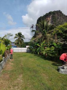 eine Gruppe von Menschen steht in einem Hof mit einem Hügel in der Unterkunft GreeneryHouseKrabi52 in Ban Chong Phli