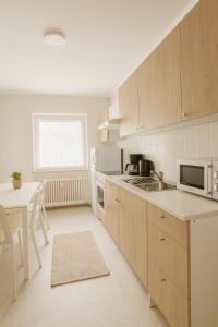 eine Küche mit Holzschränken, einem Tisch und einer Spüle in der Unterkunft SUNNYHOME Monteurwohnungen und Apartments in Weiden in Weiden + 5 Fotos