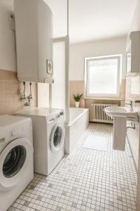 ein weißes Badezimmer mit einer Waschmaschine und einem Waschbecken in der Unterkunft SUNNYHOME Monteurwohnungen und Apartments in Weiden in Weiden