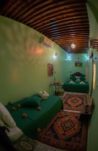 a bedroom with two green beds in a room at Riad misk lile fez in Fès