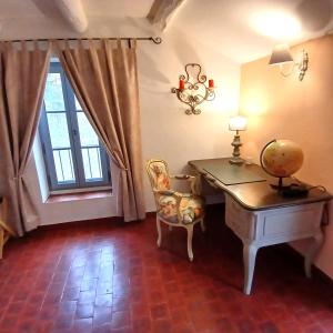Habitación con escritorio, silla y ventana. en Le Ptit Cottage, en Nyons