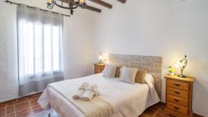 AlmácharにあるCasa Adrian Almachar by Ruralidaysのベッドとタオル2枚のある寝室