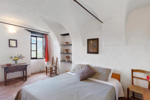 BerziA Panoramic Retreat - Unità 5的一间卧室，里面有一张白色的床、一张桌子和几把椅子