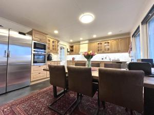 a kitchen with a table with chairs and a refrigerator at Charming Swedish Villa in Katrineholm +34 photos
