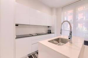 a white kitchen with a sink and a window at Apartamento Bilbo in Bilbao +29 photos