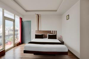 a bedroom with a large bed and a large window at Super Collection O Vaishno Devi Temple Formerly Hotel The Leaf in Katra +23 photos