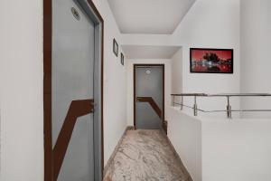 a hallway with a door and a shelf on the wall at Super Collection O Vaishno Devi Temple Formerly Hotel The Leaf in Katra