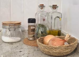 a counter with three glass bottles and a basket of onions at Villa Rosa in Melgaço +40 photos