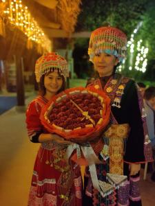 two women are holding a plate of food at Bee Lucky Homestay in Hai Phong