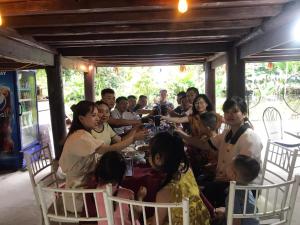 a group of people sitting around a table at Bee Lucky Homestay in Hai Phong