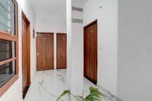 a hallway with wooden doors and marble floors at Super Hotel O ISBT Mohali Formerly Holiday Spot in Mohali