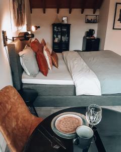 una habitación con una cama y una mesa con una bandeja de comida en Sjiek Basiliek, en Oudenbosch