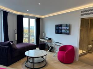 a living room with a couch and a red chair at Eiffel Yard Hotel in Paris