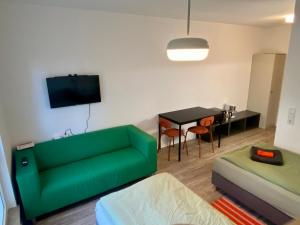 a living room with a green couch and a table at Work&Travel WE13 - Parkplatz, Netflix, Internet für 2 Gäste in Markranstädt