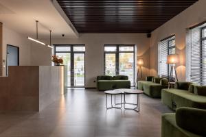 a lobby with green couches and a table at WOL GREEN Polyana by Ribas in Polyana