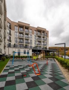 an empty playground in front of a building at WOL Green Polyana in Polyana