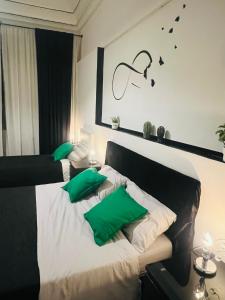 een slaapkamer met 2 bedden en groene kussens bij Ventimiglia 138 House in Catania