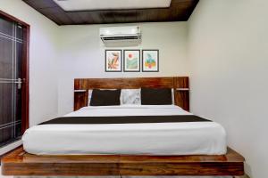 a bedroom with a bed with a wooden headboard at Townhouse Sheesh Mahal Farrukh Nagar in Farrukhnagar