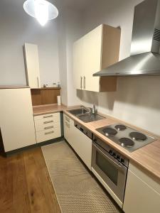 a kitchen with white cabinets and a stove top oven at Ferienwohnung C und D in Oberthulba +3 photos