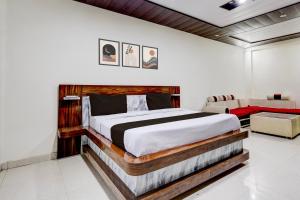 a bedroom with a large bed and a couch at Townhouse Sheesh Mahal Farrukh Nagar in Farrukhnagar