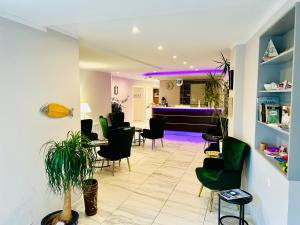 a waiting room with green chairs and a piano at tauwerk Hotel in Wilhelmshaven