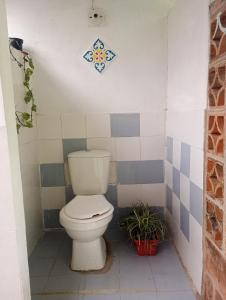 a bathroom with a toilet and a tile wall at Casa Refugio LA TEBAIDA in Mocoa