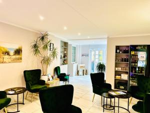 a waiting room with green chairs and tables at tauwerk Hotel in Wilhelmshaven