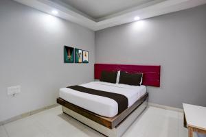 een slaapkamer met een bed met een rood hoofdeinde bij Super Collection O Paithan Gate Formerly Rajlaxmi Executive in Aurangabad