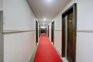 een rode loper loopt door een gang met deuren bij Super Collection O Paithan Gate Formerly Rajlaxmi Executive in Aurangabad