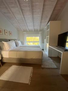 a bedroom with a large bed and a window at Giardinia Holiday Homes with Private Pool in Gazátika +45 photos
