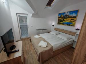 a bedroom with a bed and a painting on the wall at Alpine Relax free spa & pool in Pamporovo +107 photos