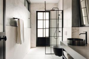 a bathroom with a shower and a black sink at Centrale Lustica Bay by Angsana in Radovići +31 photos