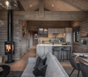 an open kitchen and living room with a couch and fireplace at Skjonnhet Cottage - Luxury Ski-in & ski-out chalet in Kvitfjell +16 photos