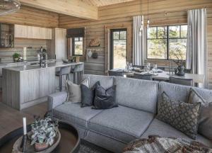 a living room with a couch and a kitchen at Skjonnhet Cottage - Luxury Ski-in & ski-out chalet in Kvitfjell
