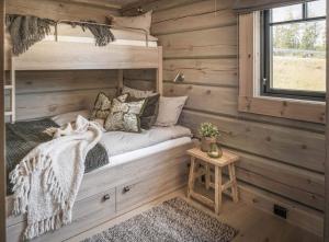 a bedroom in a tiny house with a bed and a window at Skjonnhet Cottage - Luxury Ski-in & ski-out chalet in Kvitfjell