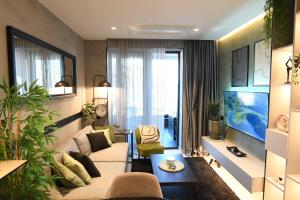 a living room with a couch and a tv at KRUNA 406 Apartment in Budva