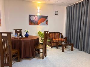 a room with a table and chairs and curtains at The Kandy Look Homestay in Kandy