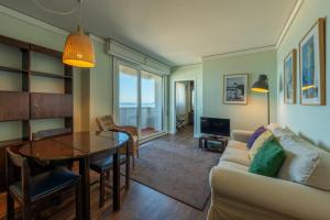 a living room with a table and a couch at Hotel Apartamento Solverde in Espinho