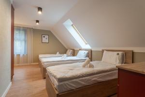 - une rangée de lits dans une chambre mansardée dans l'établissement Willa Bukowy Las - Everslow, à Szklarska Poręba