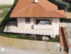 a house with two cats sitting on a balcony at Case vacanza Barbatoja in Fetovaia