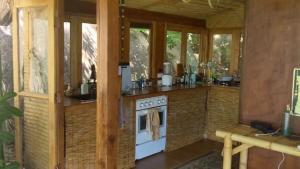 a kitchen with a stove in a room with windows at Why Nam Stunning Beach & Ocean View Jungle Penthouse in Ko Phangan +51 photos