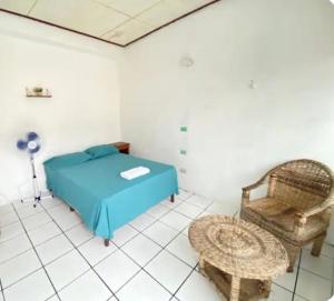 a bedroom with a blue bed and a chair at Casa Andrea in Flores