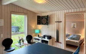 a room with a table and chairs and a bedroom at Awesome Home In Væggerløse With Sauna in Marielyst