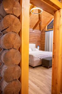 a bedroom with a bed in a log cabin at Karpet Dilijan in Dilijan +30 photos