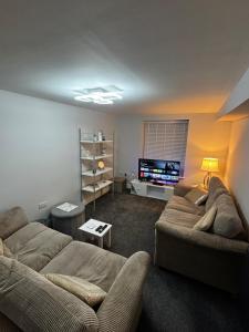 Una sala de estar con dos sofás y un televisor de pantalla plana. en Spacious Modern flat Blackburn, en Blackburn