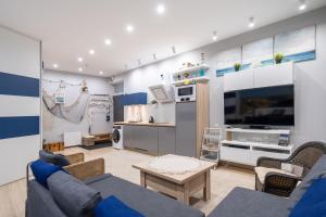 100m to Sea Beachside Studio with Private Garden & Terrace في يورمالا: غرفة معيشة مع أريكة زرقاء وطاولة