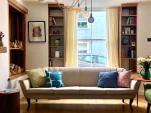 a living room with a couch and a window at Mid-Century Gem - Heart of Frome in Frome