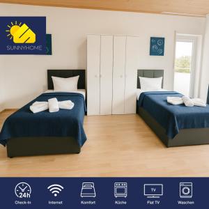 2 Betten in einem Schlafzimmer mit blauer Bettwäsche und Handtüchern in der Unterkunft SUNNYHOME Monteurwohnungen und Apartments in Weiden in Weiden